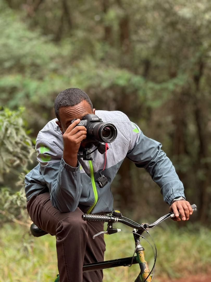 Kamil Ahmed filming in the field with a Canon camera