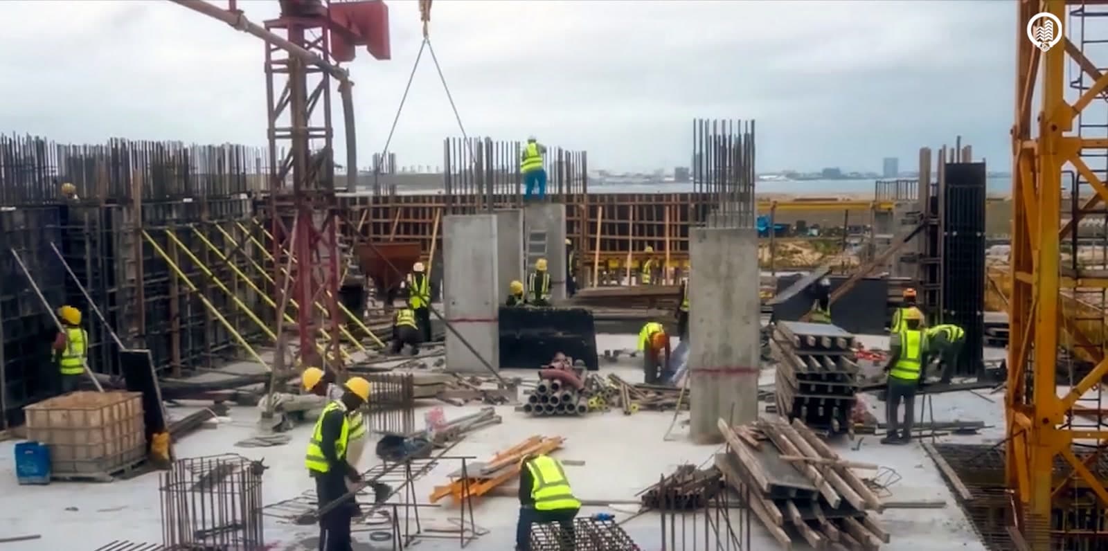 Construction workers on a high-rise site above the coast